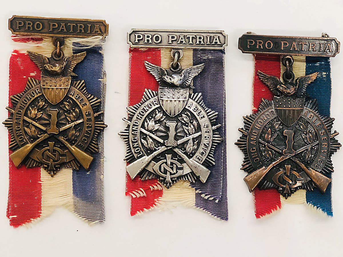 Silver and bronze versions of the Illinois 1st Infantry Long & Honorable Service medal with their “Pro Patria” brooch and draped tri-color ribbon.